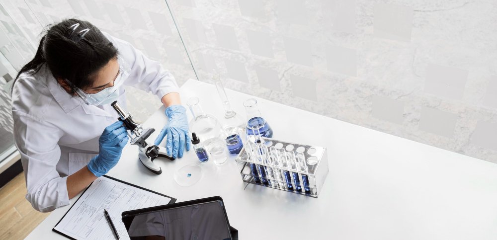 Laboratory technician analyzing blood samples with a microscope